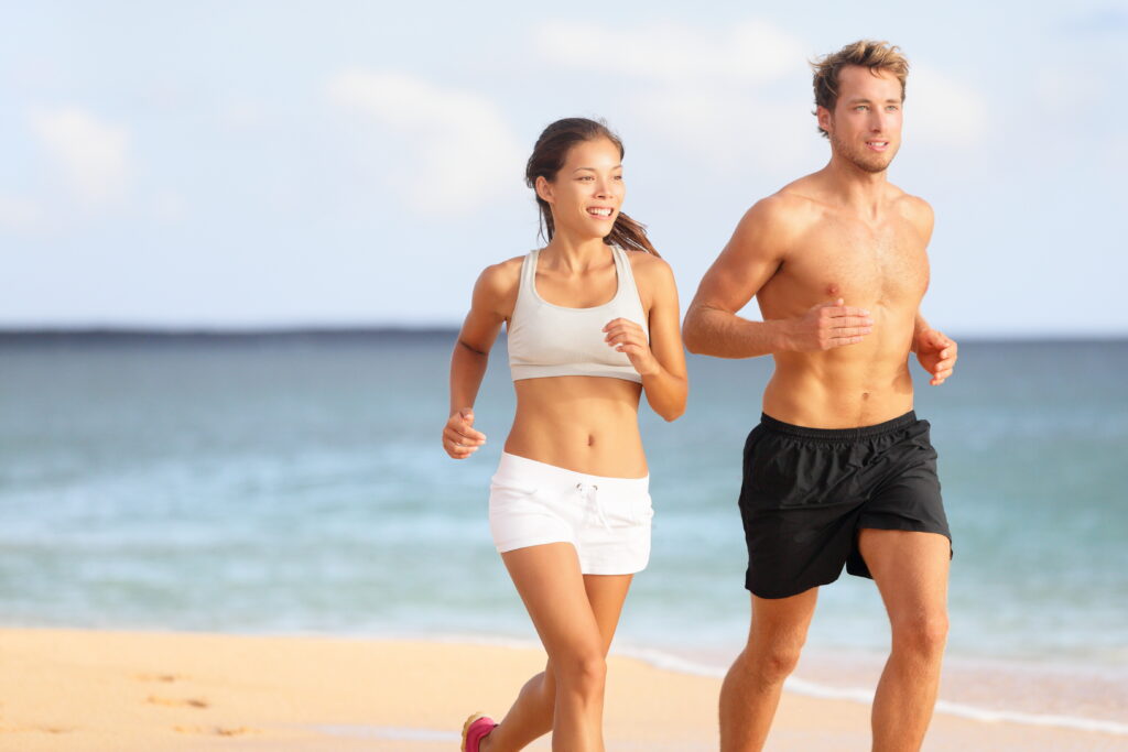 Couple Running. Sport Runners Jogging On Beach Working Out Smiling